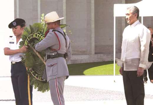 US Ambassador to Manila Sung Kim stands at attention as members of the military offer a wreath at the Manila American Cemetery in Taguig City.