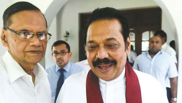 Sri Lankau2019s former president Mahinda Rajapakse, right, leaves the official residence in Colombo yesterday.