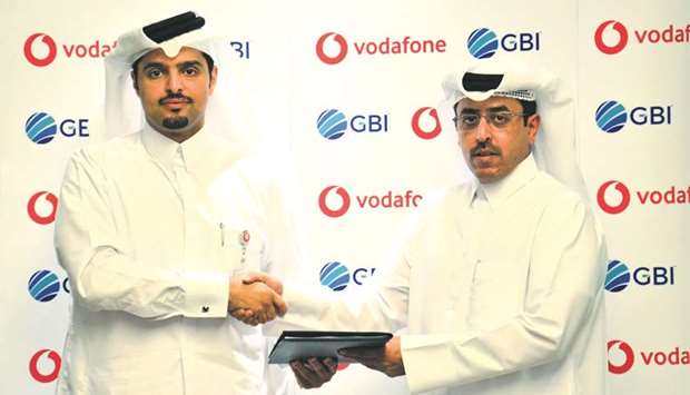 Vodafone Qatar CEO Sheikh Hamad bin Abdulla al-Thani and GBI executive director and managing director Abdulla al-Ruwali shake hands after signing an agreement.