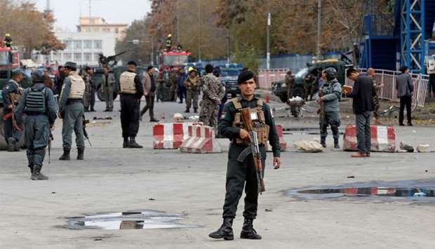 Afghan policemen keep watch at the site of a blast in Kabul