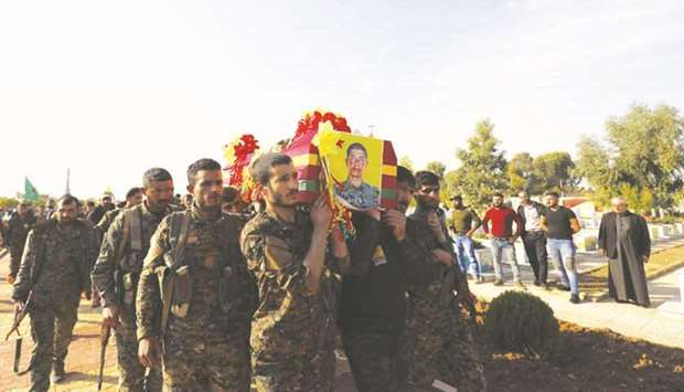 Fighters from the Syrian Democratic Forces (SDF), carry the coffin of a fellow fighter, killed during a military mission, in the Kurdish-controlled city of Qamishly in northeastern Syria, yesterday.