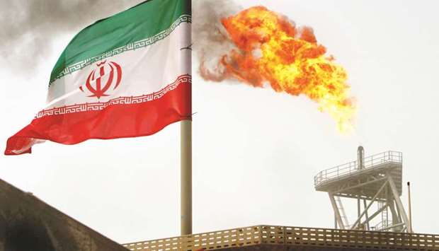 A gas flare on an oil production platform in the Soroush oilfields is seen alongside an Iranian flag (file). The waivers would ensure at least some Iranian oil continues to flow to the global market, potentially calming fears of a supply crunch and further suppressing international oil prices just before mid-term elections in the US.