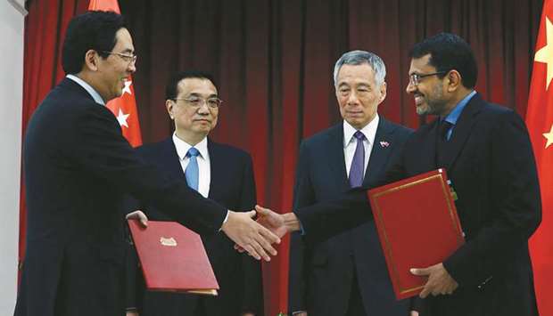 Chinese Premier Li Keqiang (2nd from left) and Singaporeu2019s Prime Minister Lee Hsien Loong (2nd from right) witness an exchange of a memorandum of understanding during a meeting at the Presidential Palace on the sidelines of the 33rd Association of Southeast Asian Nations summit in Singapore yesterday. Li said China would u201cwork with all relevant parties to expediteu201d negotiations on the Regional Comprehensive Economic Partnership (RCEP), showcased to be a free trade deal that will encompass more than a third of the worldu2019s GDP.