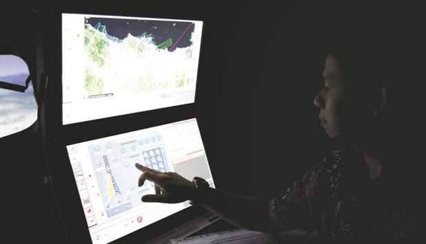 A senior pilot of Lion Air Group points at the control computer as he supervises during a routine practice session on Boeing 737-900ER simulator at Angkasa Training Center near Jakarta, Indonesia.