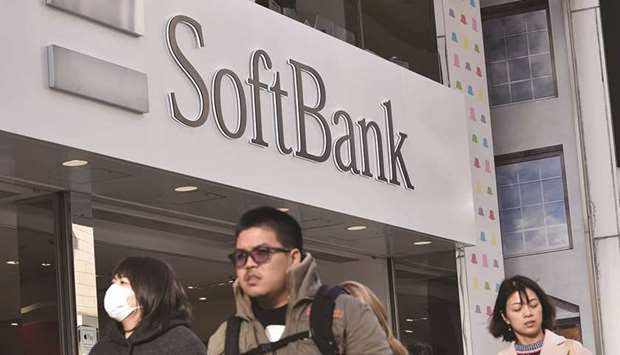 People walk past a shop of SoftBank in Tokyou2019s shopping district of Ginza. The Japanese technology giant said in a prospectus yesterday it will sell 1.6bn shares at u00a51,500 apiece in a new entity, SoftBank Corp, that will start trading on December 19.