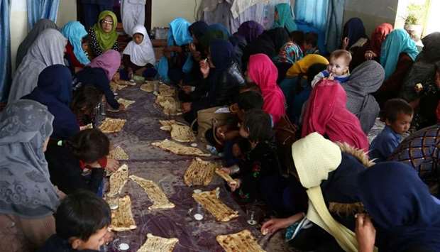 Internally displaced Afghans eat breakfast after arriving from Jaghori district of Ghazni fleeing ongoing battles between Taliban and Afghan security forces
