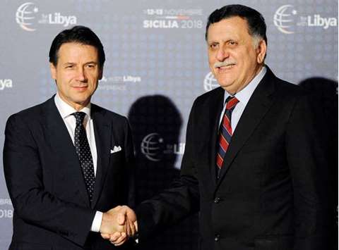 Italyu2019s Prime Minister Giuseppe Conte with Libyau2019s Prime Minister Fayez al-Sarraj as he arrives at the venue of the international conference on Libya in Palermo, yesterday.