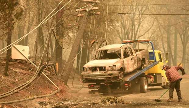 Crews begin removing vehicles from the streets after the Camp fire tore through the area in Paradise, California