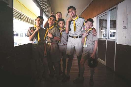 Rapper Elevenfinger, second right, posing with students in scout uniforms at a government school in Bangkok.