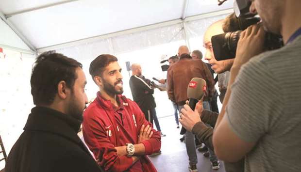 Qatar captain Hassan al-Haydos and coach Felix Sanchez (background) speak to the Swiss media in Lugano yesterday.
