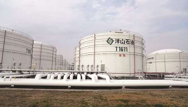 Oil tanks are seen at a warehouse at Yangshan port in Shanghai. China will import about 1.33mn bpd of mostly Angolan crude in November, down from Octoberu2019s record 1.935mn bpd.