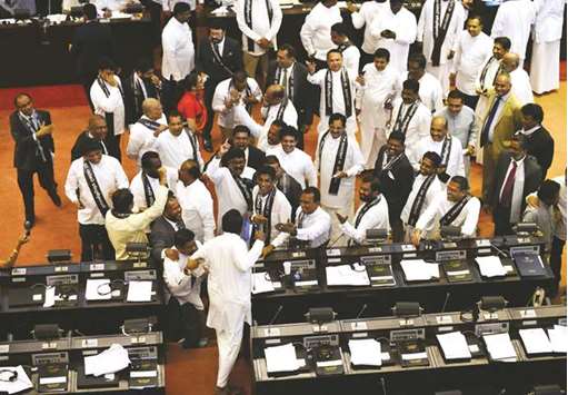 Members of the Sri Lankan parliament shout slogans in support of ousted prime minister Ranil Wickremesinghe during a parliament session in Colombo yesterday.