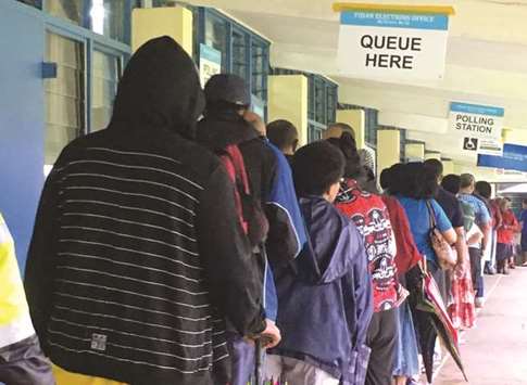 Voters stand in a line to enter a polling venue during voting for Fijiu2019s general election near Suva, in the South Pacific nation of Fiji.