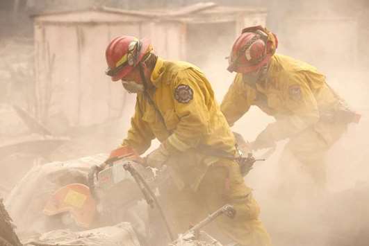 Cal Fire firefighters comb through a house destroyed by the Camp Fire in Paradise.