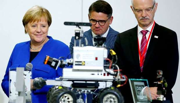 German Chancellor Angela Merkel, Hesse's Science Minister Boris Rhein and President of Darmstadt University of Technology (TU Darmstadt) Hans Jurgen Promel attend a demonstration of a rescue robot at the university in Darmstadt, Germany