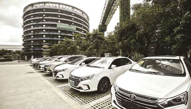 BYD vehicles stand in front of a charging parking lot tower at the companyu2019s headquarters in Shenzhen, China (file). Starting in January, all major manufacturers operating in China u2014 from global giants Toyota Motor and General Motors to domestic players BYD and BAIC Motor u2014 have to meet minimum requirements there for producing new-energy vehicles, or NEVs (plug-in hybrids, pure-battery electrics, and fuel-cell autos). A complex government equation requires that a sizable portion of their production or imports must be green in 2019, with escalating goals thereafter.