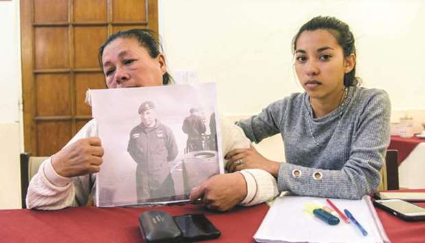 Francisca Soria (left) and Lourdez Melian, mother and sister of Argentinian missing crew member David Melian, show his picture at a military hotel in Mar del Plata.