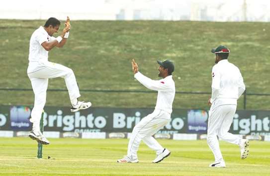 In this October 19, 2018, picture, Pakistanu2019s bowler Mohamed Abbas (left) celebrates with teammate after dismissing Australian batsman Travis Head (not pictured) on day four of the second Test in Abu Dhabi. (AFP)