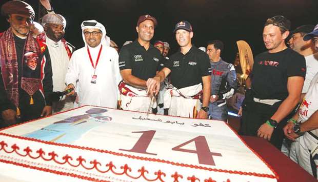Nasser Saleh al-Attiyah (also left) cuts a cake to celebrate his record 14th MERC title in the presence of QMMF President Abdulrahman al-Mannai and other drivers.