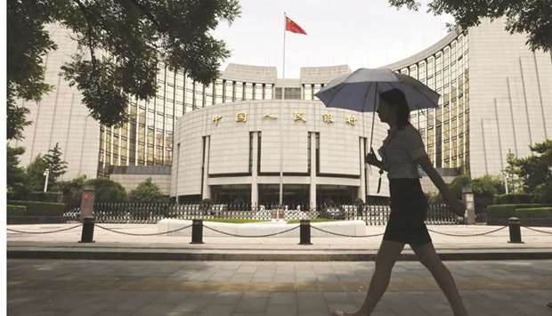 A pedestrian walks past the Peopleu2019s Bank of China headquarters in Beijing. The PBoC has not cut its benchmark 1-year lending rate since October 2015 u2013 it is now 4.35% u2013 opting instead to use other more targeted policy tools to influence borrowing costs, such as extending more loans specifically to struggling sectors.