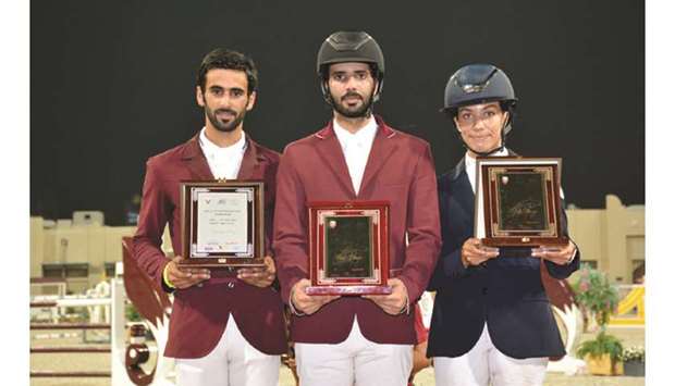 Winner Mubarak Yousuf al-Rumaihi (centre), runner-up Rashid Towaim al-Marri (left) and third-placed Cyrine Cherif pose with their trophies. at the Qatar Equestrian Federationu2019s outdoor arena.