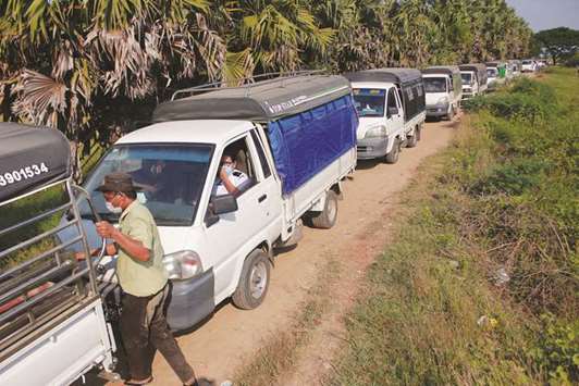 Vehicles line up to transport Rohingya Muslims detained by Myanmar immigration authorities after arriving by boat at Thande village outside Yangon yesterday.
