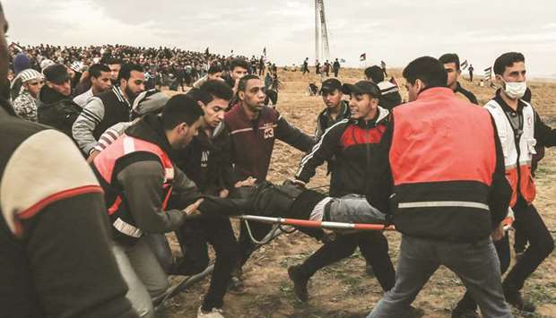 Palestinian men carry an injured man during a protest yesterday, on the eastern outskirts of Gaza City.