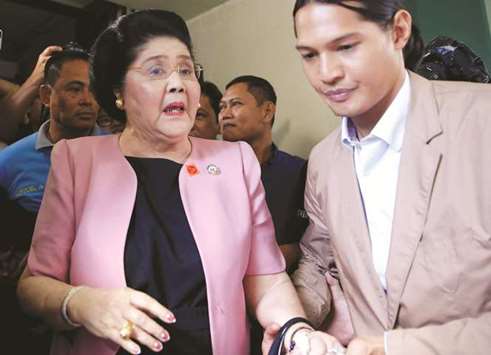 Former First Lady Imelda Marcos leaves Sandiganbayan anti-corruption court with her grandson after attending a court hearing in Quezon City, Metro Manila, yesterday.