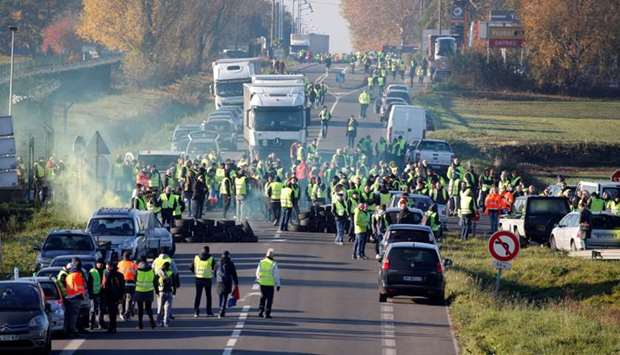 People wearing yellow vests, a symbol of a French drivers' nationwide protest against higher fuel prices, block the Paris-Brussels motorway in Haulchin, France
