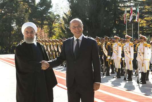 Iraqu2019s President Barham Salih (right) is welcomed by Iranu2019s President Hassan Rouhani during his visit in Tehran yesterday. Iran and Iraq could raise annual bilateral trade to $20bn from the current level of $12bn, Rouhani said yesterday, despite concerns over the economic impact of renewed US sanctions.