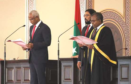 Maldivesu2019 President-elect Ibrahim Mohamed Solih, left, takes the oath conducted by Chief Justice Ahmed Abdulla Didi, right, during the swearing-in ceremony in Male yesterday.
