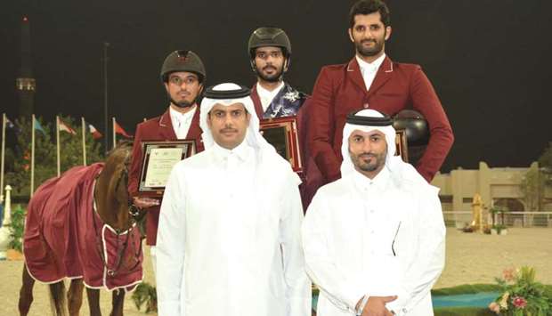 Qatar Equestrian Federation president Hamad bin Abdulrahman al-Attiyah  (bottom left) and Event director Ali al-Rumaihi pose with the podium winners of the Grand Prix at Qatar Equestrian Federationu2019s outdoor arena.
