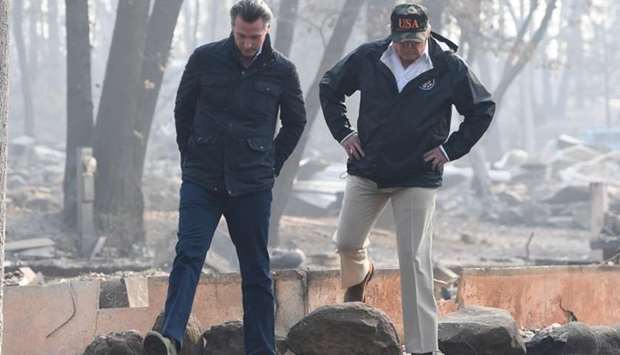 US President Donald Trump walks with Lieutenant Governor of California, Gavin Newsom, as they view damage from wildfires in Paradise, California