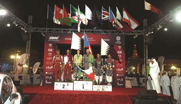 Czech driver Vojtech Stajf (third from right) and his navigator Veronika Havelkova (third from left), winners of the Manateq International Rally of Qatar pose on the podium with runners-up Adel Abdulla (second from left) of Qatar and navigator Ziad Chebab (left), and third-placed driver Abdullah al-Kuwari and navigator Nasser al-Kuwari, both from Qatar, yesterday.