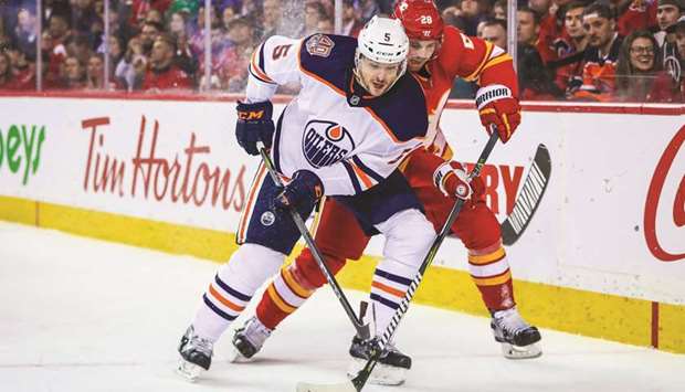 Edmonton Oilers defenseman Kevin Gravel and Calgary Flames center Elias Lindholm (right) battle for the puck during the third period of their NHL game at Scotiabank Saddledome. PICTURE: USA TODAY Sports