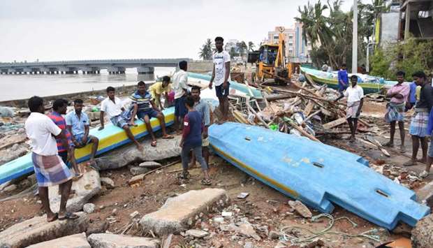 Indian people look at debris of boats in Velankanni in India's southern Tamil Nadu state on Friday.
