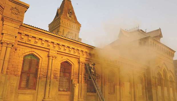 A worker uses a sandblasting technique to clean the British-era Empress Market building, constructed between 1884 and 1889, in Karachi.