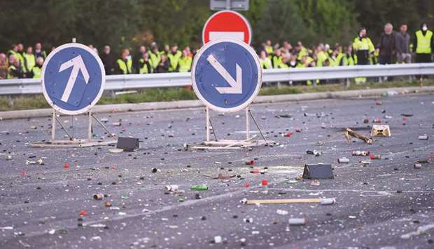 Objects and road signs are seen on the road as protesters face riot police while blocking the A10 motorway in Virsac, near Bordeaux, southwestern France, yesterday, on a second day of demonstrations against fuel prices.