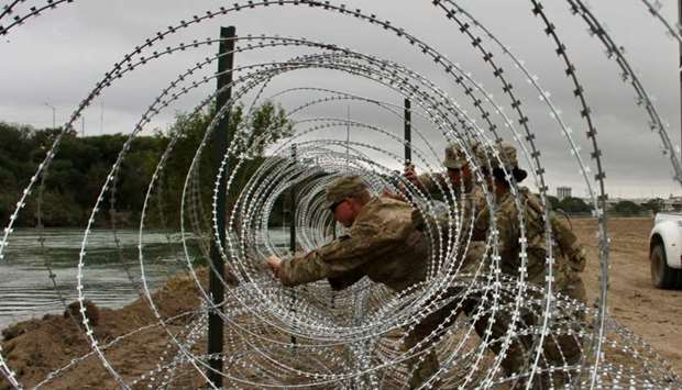 Soldiers from the Kentucky-based 19th Engineer Battalion are installing barbed wire fences on the banks of the Rio Grande in Laredo yesterday.