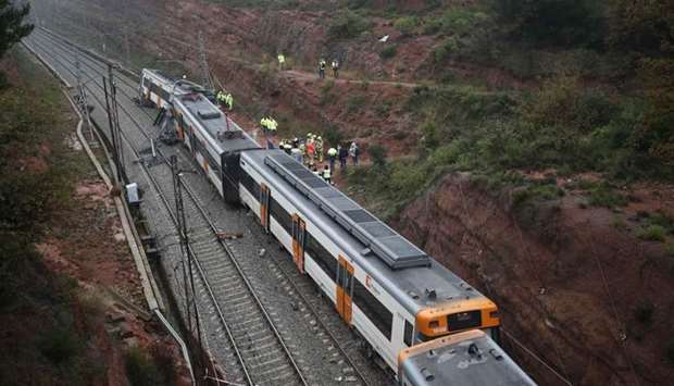 Rescue workers survey the scene after a commuter train derailed between Terrassa and Manresa, outside Barcelona, Spain