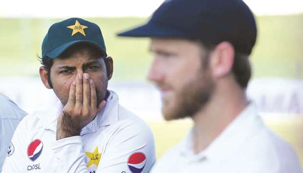 Dejected Pakistani captain Sarfraz Ahmed (left) and his New Zealand counterpart Kane Williamson after the first Test in Abu Dhabi yesterday. (AFP)