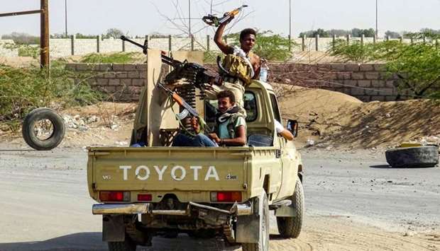 Yemeni pro-government forces cheer as they ride in the back of a pickup truck mounted with a machine gun as they drive in an industrial district in the eastern outskirts of the port city of Hodeida. AFP