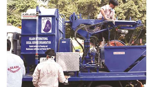 Workers scrub a sewer cleaning machine on a truck before its unveiling during an event to celebrate World Toilet Day in New Delhi yesterday.