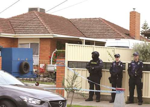 Policemen stand guard outside one of the houses involved in counter-terrorism raids across the north-western suburbs in Melbourne, Australia, yesterday.