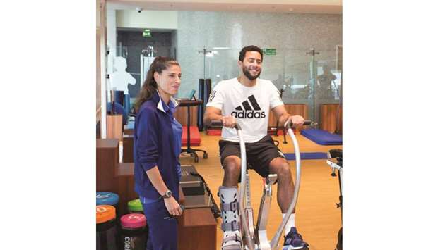 Tottenham Hotspuru2019s Mousa Dembele (right) with an Aspetar medical team member during his recovery from a recent ankle injury.