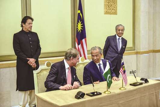 Pakistanu2019s Prime Minister Imran Khan and Malaysiau2019s Prime Minister Mahathir Mohamed witness a signing ceremony at the Prime Minsiteru2019s Office in Putrajaya, near Kuala Lumpur, yesterday.