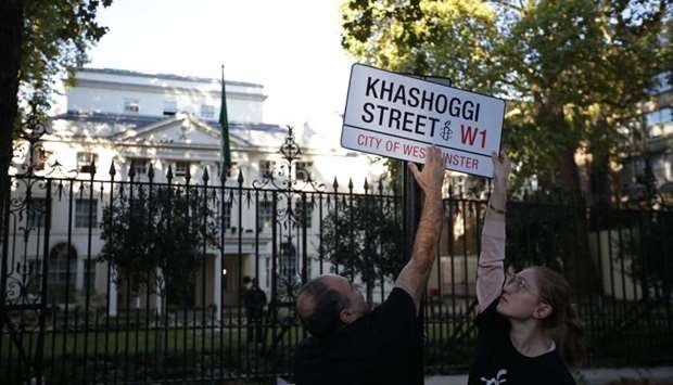 A mock street sign reading ,Khashoggi Street, is erected by Amnesty International activists on the street in front of the Embassy of Saudi Arabia in London.