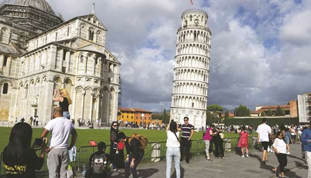 This file photo taken on September 12, 2017 shows tourists posing for photographs at the Pisa tower.