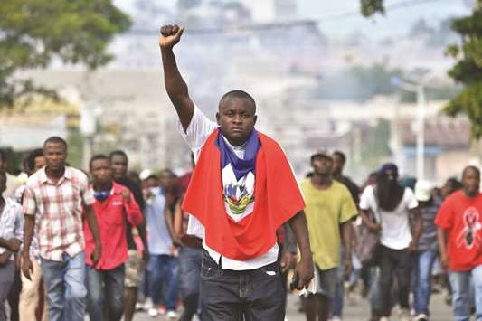 A man holds up his fist as demonstrators march through the streets of Port-au-Prince demanding the resignation of Haitian President Jovenel Moise.