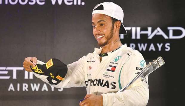 Mercedesu2019 British driver Lewis Hamilton celebrates on the podium after winning the Abu Dhabi Formula One Grand Prix at the Yas Marina circuit yesterday. (AFP)
